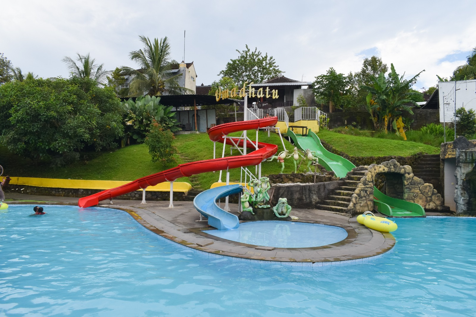 Front view of Kampung Inggris Nature Bali building with white and yellow walls and red door frame