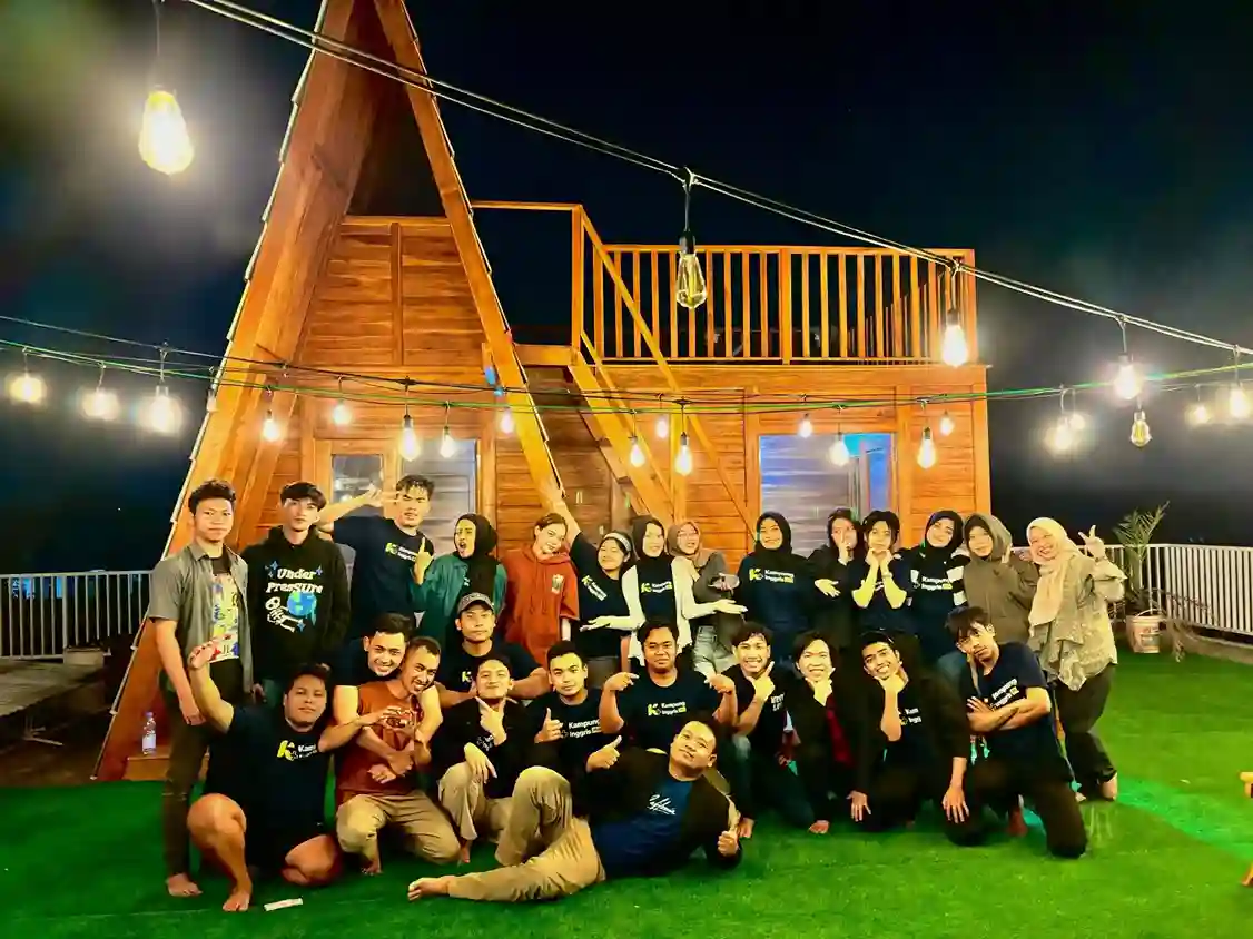Suasana belajar di Kampung Inggris Nature dengan latar belakang pepohonan hijau dan siswa yang sedang berdiskusi santai di luar ruangan